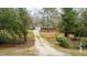 Exterior view of home set back from the road among mature trees with a gravel driveway and mailbox at 2010 Twin Acres Rd, Clayton, NC 27520