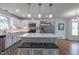 Spacious kitchen with white cabinets, quartz countertops, stainless appliances, island with stools and stylish pendant lights at 2010 Twin Acres Rd, Clayton, NC 27520