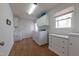 Functional laundry room equipped with white cabinets and modern washer/dryer at 2010 Twin Acres Rd, Clayton, NC 27520