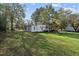 Spacious backyard with a well-manicured lawn, mature trees, and a charming home in the background at 219 N Richardson Ave, Nashville, NC 27856