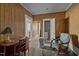 Bedroom with wooden walls and a connected bathroom and kitchen view; features a desk, a chair, and a rocking chair at 219 N Richardson Ave, Nashville, NC 27856