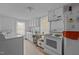 Compact kitchen with white appliances and cabinets; includes a washer, dryer, and a view of the outside at 219 N Richardson Ave, Nashville, NC 27856