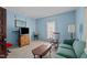 A cozy living room featuring comfortable seating, vintage furniture, and natural light from the window at 219 N Richardson Ave, Nashville, NC 27856