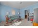 A relaxing living room featuring a sofa, rocking chair, a piano, and soft, neutral carpeting at 219 N Richardson Ave, Nashville, NC 27856