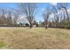 Large backyard featuring lawn, tall trees and a basketball court at 2605 Sumac Ln, Burlington, NC 27215