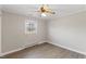 This bedroom features neutral walls, a ceiling fan, and modern gray vinyl plank flooring at 2605 Sumac Ln, Burlington, NC 27215
