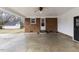 Attached carport with concrete flooring, a brick wall, and a beadboard ceiling at 2605 Sumac Ln, Burlington, NC 27215