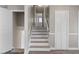 Hallway shows a staircase with wood railings and treads, with wood flooring in the hallway at 2605 Sumac Ln, Burlington, NC 27215