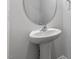 Modern bathroom with a white pedestal sink and oval mirror at 266 Hanging Elm Ln, Fuquay Varina, NC 27526
