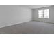 Spacious bedroom features carpeted floors and natural light from a large window at 266 Hanging Elm Ln, Fuquay Varina, NC 27526