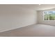 A bright carpeted bedroom with neutral walls, a window, and a recessed ceiling light at 266 Hanging Elm Ln, Fuquay Varina, NC 27526