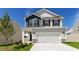 Charming two-story home featuring a gray exterior, black shutters, and a spacious two-car garage at 266 Hanging Elm Ln, Fuquay Varina, NC 27526