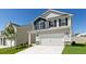 Charming two-story home featuring a gray exterior, black shutters, and a spacious two-car garage at 266 Hanging Elm Ln, Fuquay Varina, NC 27526