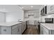 Modern kitchen featuring a large island with quartz countertops, stainless steel appliances, and gray cabinets at 266 Hanging Elm Ln, Fuquay Varina, NC 27526