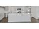 Modern kitchen featuring a large island with quartz countertops, stainless steel appliances, and gray cabinets at 266 Hanging Elm Ln, Fuquay Varina, NC 27526