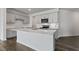 Modern kitchen featuring a large island with quartz countertops, stainless steel appliances, and gray cabinets at 266 Hanging Elm Ln, Fuquay Varina, NC 27526