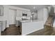 Modern kitchen featuring a large island with quartz countertops, stainless steel appliances, and gray cabinets at 266 Hanging Elm Ln, Fuquay Varina, NC 27526