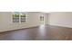 Living room with wood flooring, a large window and sliding glass door leading to the backyard at 266 Hanging Elm Ln, Fuquay Varina, NC 27526