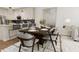 Cozy dining area with a wooden table set for eight, adjacent to a modern kitchen and living space at 4073 Elk Creek Ln, Raleigh, NC 27612