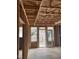 Unfinished living room showcasing the bare framework, windows, and door that leads to the backyard at 4073 Elk Creek Ln, Raleigh, NC 27612