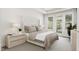 Serene main bedroom with a tufted headboard, plush bedding, and balcony access at 4073 Elk Creek Ln, Raleigh, NC 27612