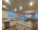 Open-concept kitchen with granite island flows into a spacious living area with multiple windows at 544 John Stark Dr, Fuquay Varina, NC 27526