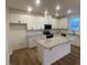 Bright kitchen featuring white cabinets, granite countertops, and a spacious center island at 544 John Stark Dr, Fuquay Varina, NC 27526