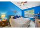 Bright bedroom featuring blue walls, a comfortable queen-sized bed, and a window with natural light at 5548 Roan Mountain Pl, Raleigh, NC 27613
