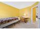 Bedroom featuring yellow walls, a small bed, chair, and small table with lamp at 5548 Roan Mountain Pl, Raleigh, NC 27613