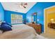 Bright bedroom featuring blue walls, a comfortable queen-sized bed, and a wooden dresser at 5548 Roan Mountain Pl, Raleigh, NC 27613