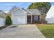 Charming single-story home with a brick accent, a garage, and a well-maintained front yard at 5548 Roan Mountain Pl, Raleigh, NC 27613