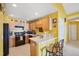 Cozy kitchen featuring wooden cabinets, black appliances, and eat-in breakfast bar with seating at 5548 Roan Mountain Pl, Raleigh, NC 27613