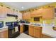 Kitchen featuring wooden cabinets, black appliances, and white countertop at 5548 Roan Mountain Pl, Raleigh, NC 27613