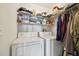 Functional laundry area features a washer and dryer, with shelving units for organized storage solutions at 5548 Roan Mountain Pl, Raleigh, NC 27613