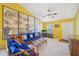 Living room featuring bright yellow walls, rattan furniture, and decorative wall art at 5548 Roan Mountain Pl, Raleigh, NC 27613