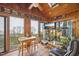 Relaxing sunroom filled with natural light, featuring wood paneling and multiple windows at 5548 Roan Mountain Pl, Raleigh, NC 27613