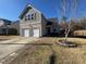 Two-story home featuring a two-car garage, neutral siding, and a manicured lawn at 5627 Quitman Trl, Raleigh, NC 27610