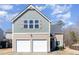 Two-story home featuring a two-car garage and stylish light green and beige exterior at 5627 Quitman Trl, Raleigh, NC 27610