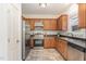 Functional kitchen with stainless steel appliances, wood cabinets, and modern backsplash at 5627 Quitman Trl, Raleigh, NC 27610