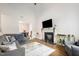 Cozy living room features a fireplace, gray sofa, hardwood floors, and an open layout at 5627 Quitman Trl, Raleigh, NC 27610