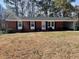 Charming one-story brick home with an attached carport and well-maintained front yard and established trees at 613 Sexton Ave, Zebulon, NC 27597