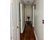 Hallway featuring wood-look floors, neutral paint, and a decorative plant at the end at 613 Sexton Ave, Zebulon, NC 27597