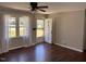Bright living room with large windows, laminate flooring, and a view of the front yard at 613 Sexton Ave, Zebulon, NC 27597