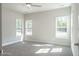 Spacious bedroom with plush carpet, ceiling fan, and abundant natural light from three large windows at 6935 Old Jefferson Hwy, Cameron, NC 28326