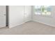 A clean bedroom space featuring light walls, neutral carpet, and a sunlit window at 865 Forth Ct # 145, Gibsonville, NC 27249