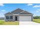 Charming single-Gathering home showcasing a gray exterior, well-manicured lawn, and a two-car garage at 865 Forth Ct # 145, Gibsonville, NC 27249