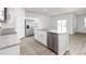 Bright kitchen featuring an island with a sink, stainless steel appliances, granite countertops, and hard surface floors at 865 Forth Ct # 145, Gibsonville, NC 27249