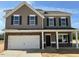 Two-story home boasts attached two-car garage, covered front porch, neutral siding and trim, and black shutters at 88 E Victory View Ter, Smithfield, NC 27577