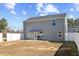 Gray home's backyard with a small patio, privacy fence, and lush trees at 1004 Bridgewater Dr, Durham, NC 27704