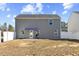 View of the home's backyard with a patio, featuring a gray exterior, awning, and white privacy fence at 1004 Bridgewater Dr, Durham, NC 27704